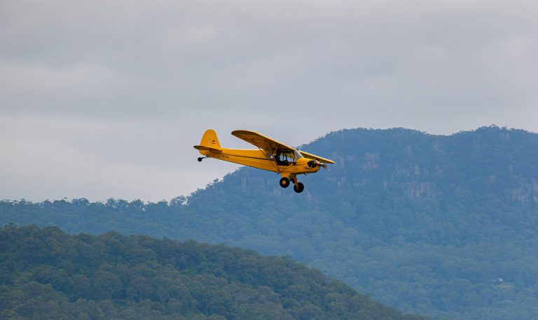 Small airplane flying over the mountains