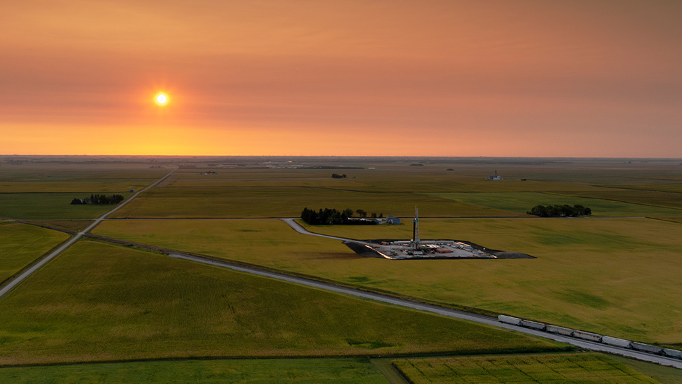 Aerial view of a drilling rig in landscape during sunset